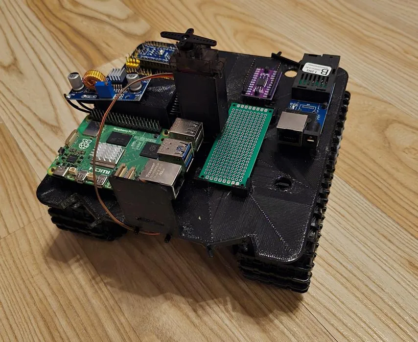 The rover's printed plate on the T101 chassis with the Pi 5, the Nano, the buck converter, the servo mast and the fibre converter